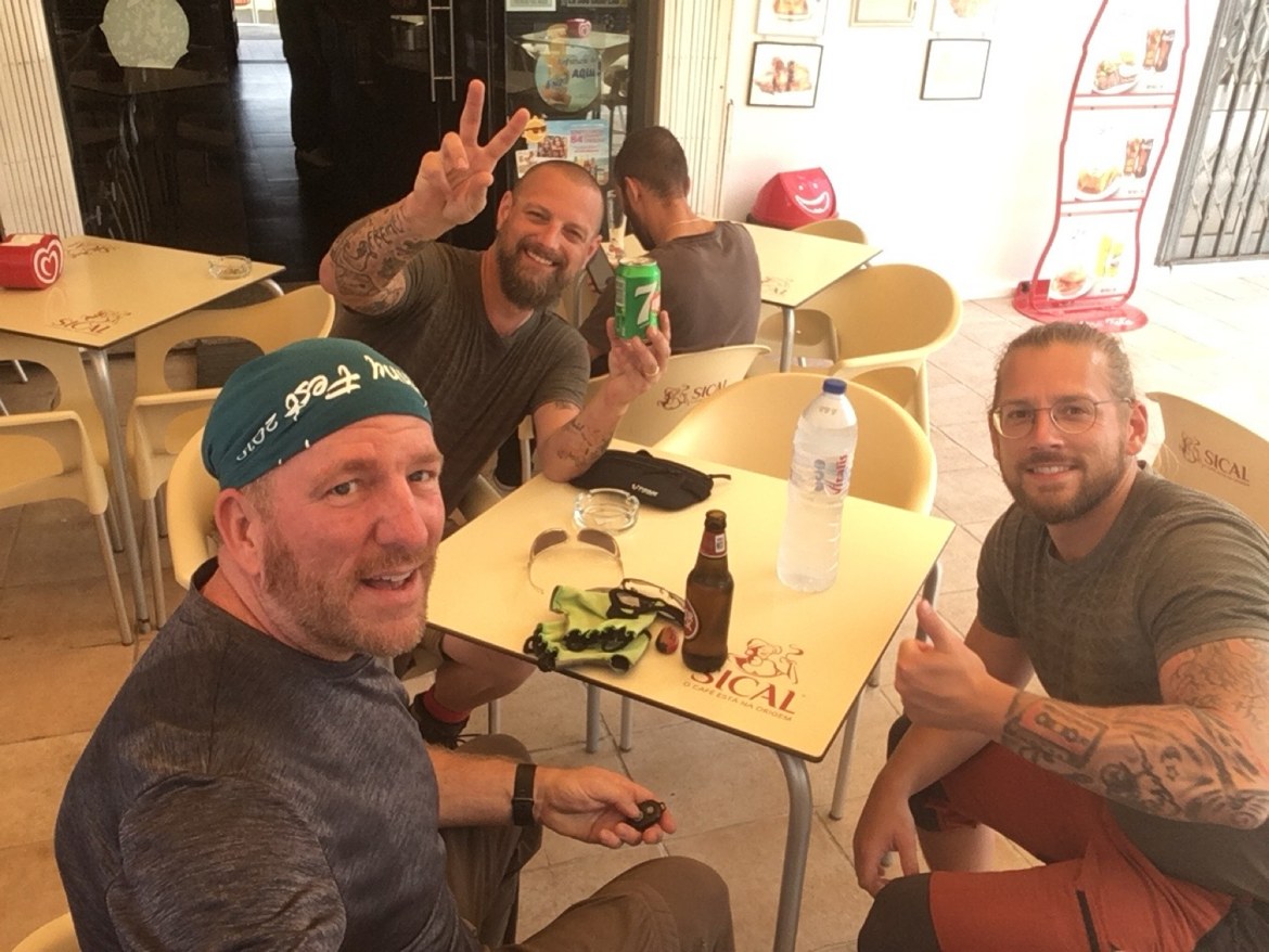 Three pilgrims taking a selfie at a café table