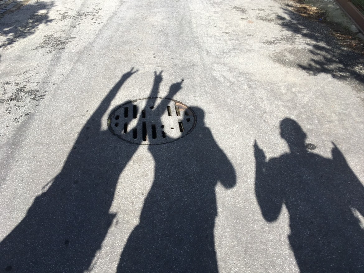 The long shadows of three pilgrims on the road