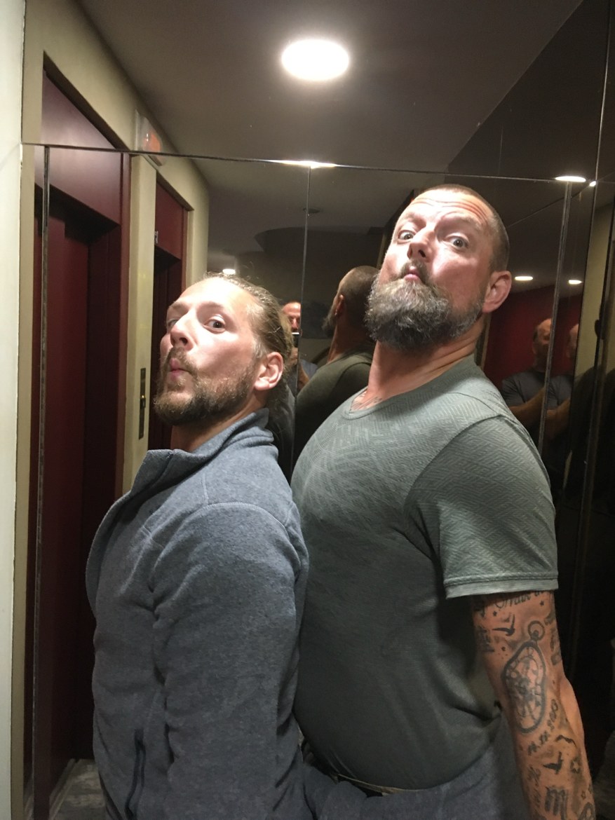 Two pilgrims pulling faces in a mirrored elevator