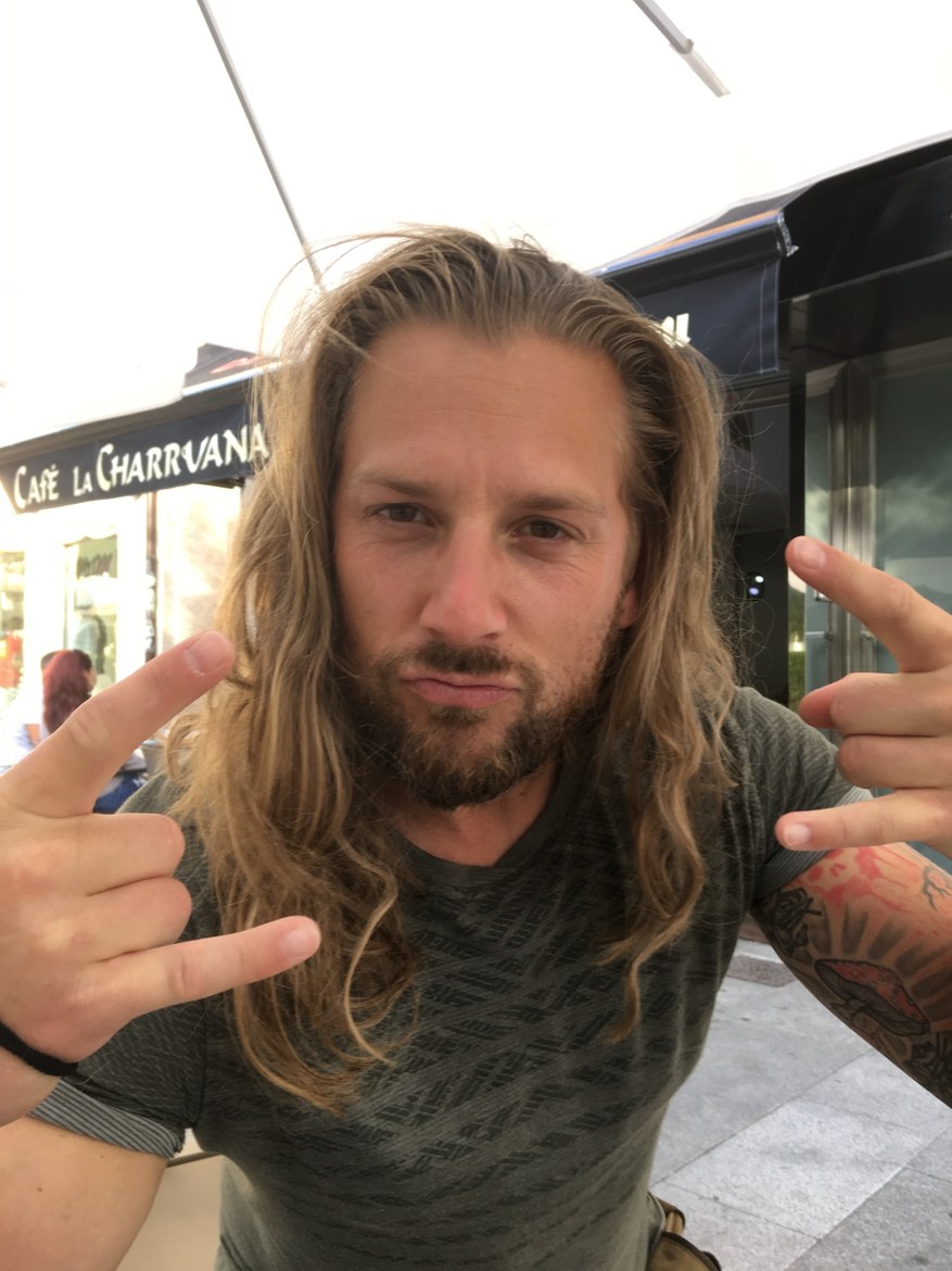 A pilgrim flashing rock horns at a café terrace
