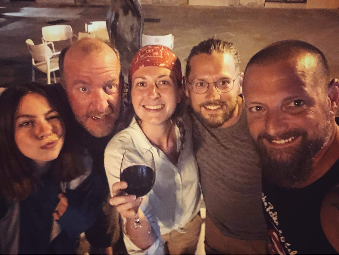 Five pilgrims sharing wine in the evening