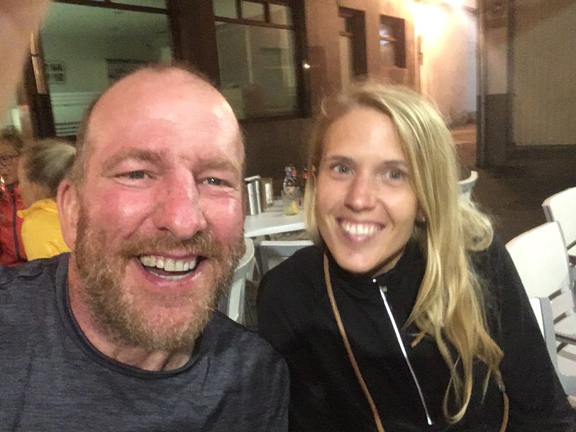 Two pilgrims smiling at a café at night