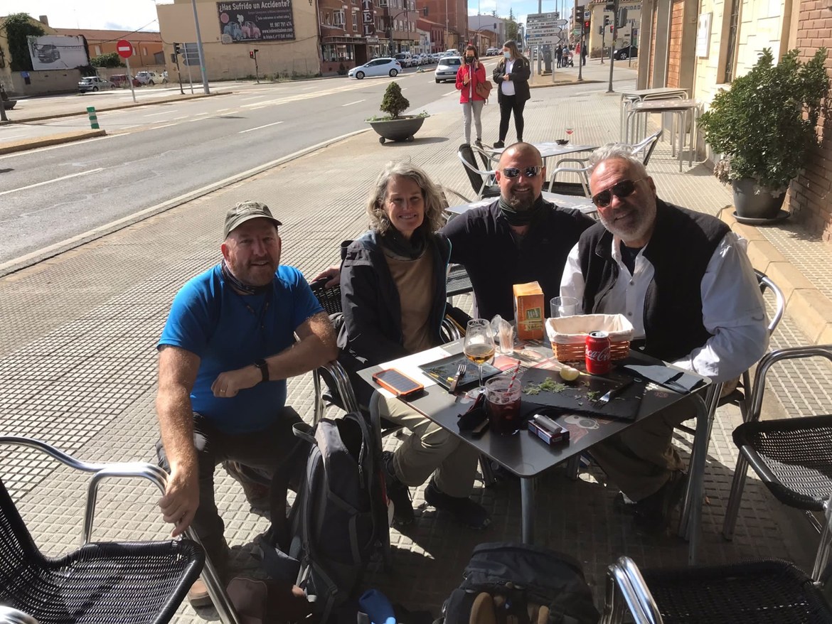 Pilgrims relaxing at a café terrace with drinks