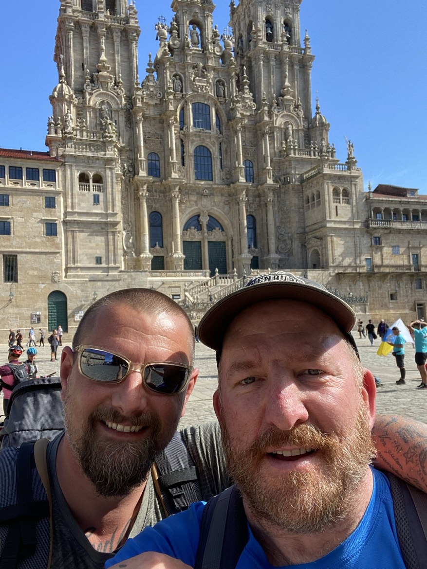 Two pilgrims taking a selfie before the cathedral in Santiago
