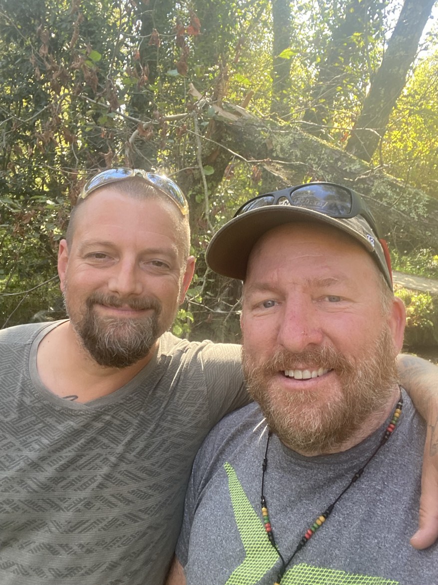 Two pilgrims smiling on a forest path