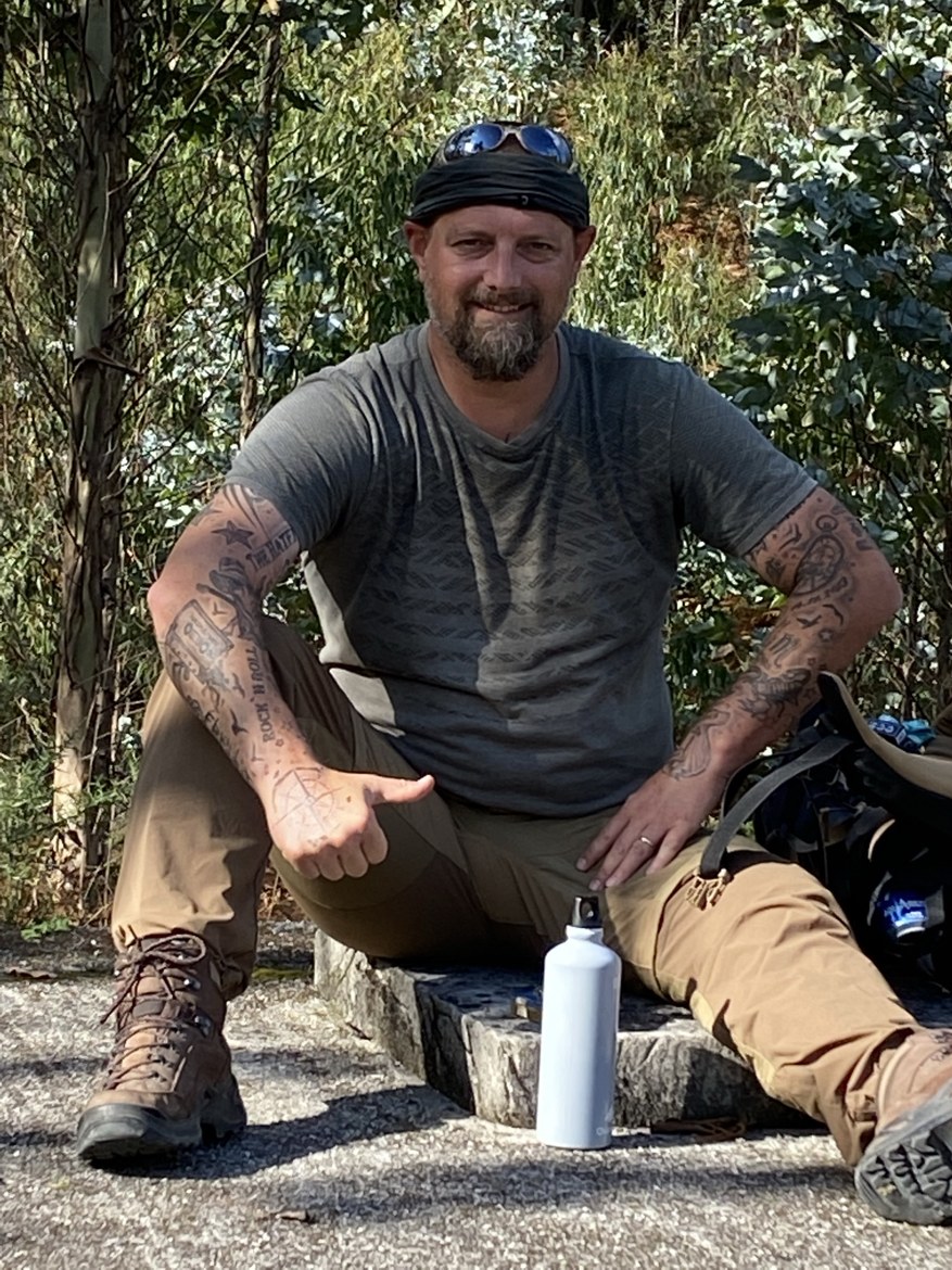 A pilgrim resting on a stone in the shade