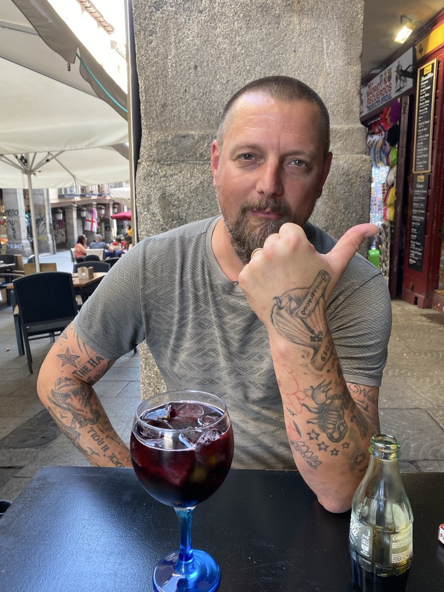 A pilgrim at a café table with a large glass of tinto de verano