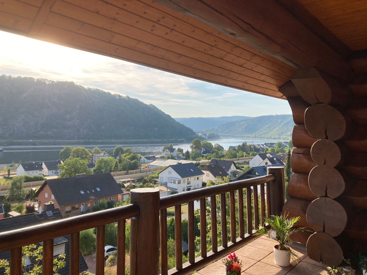 Morning light over the Rhine from a log-cabin balcony