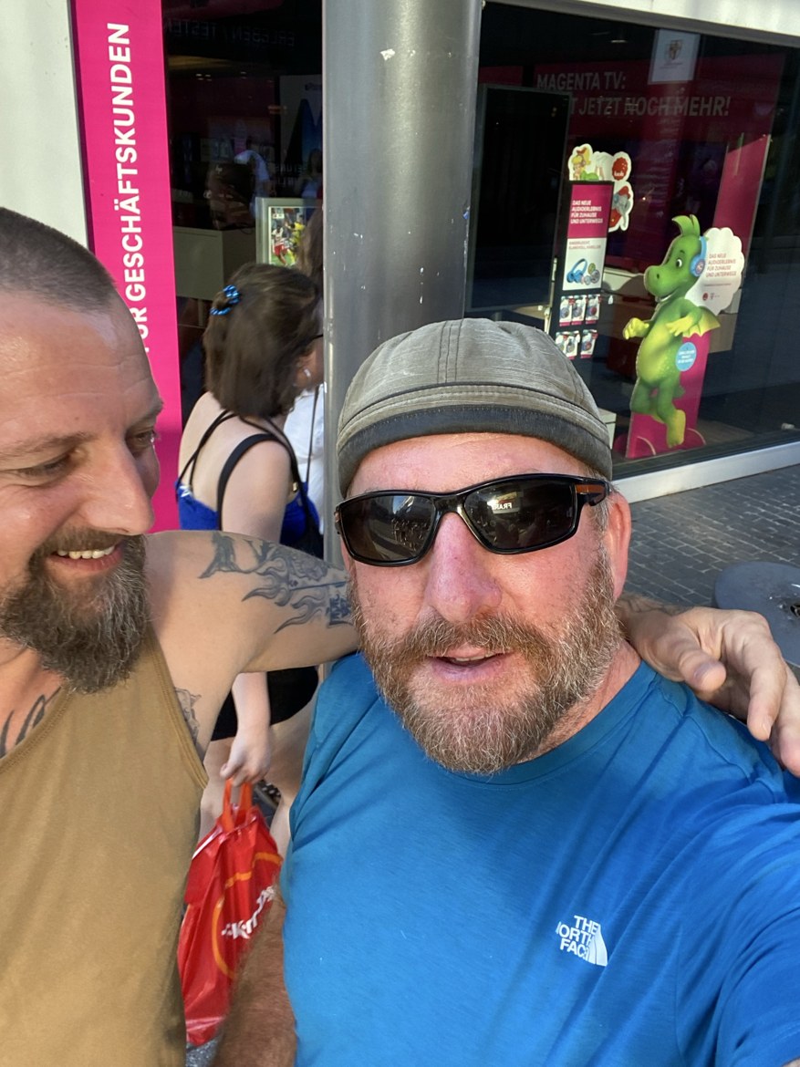 Nicki and Mike in a city street outside a Telekom shop