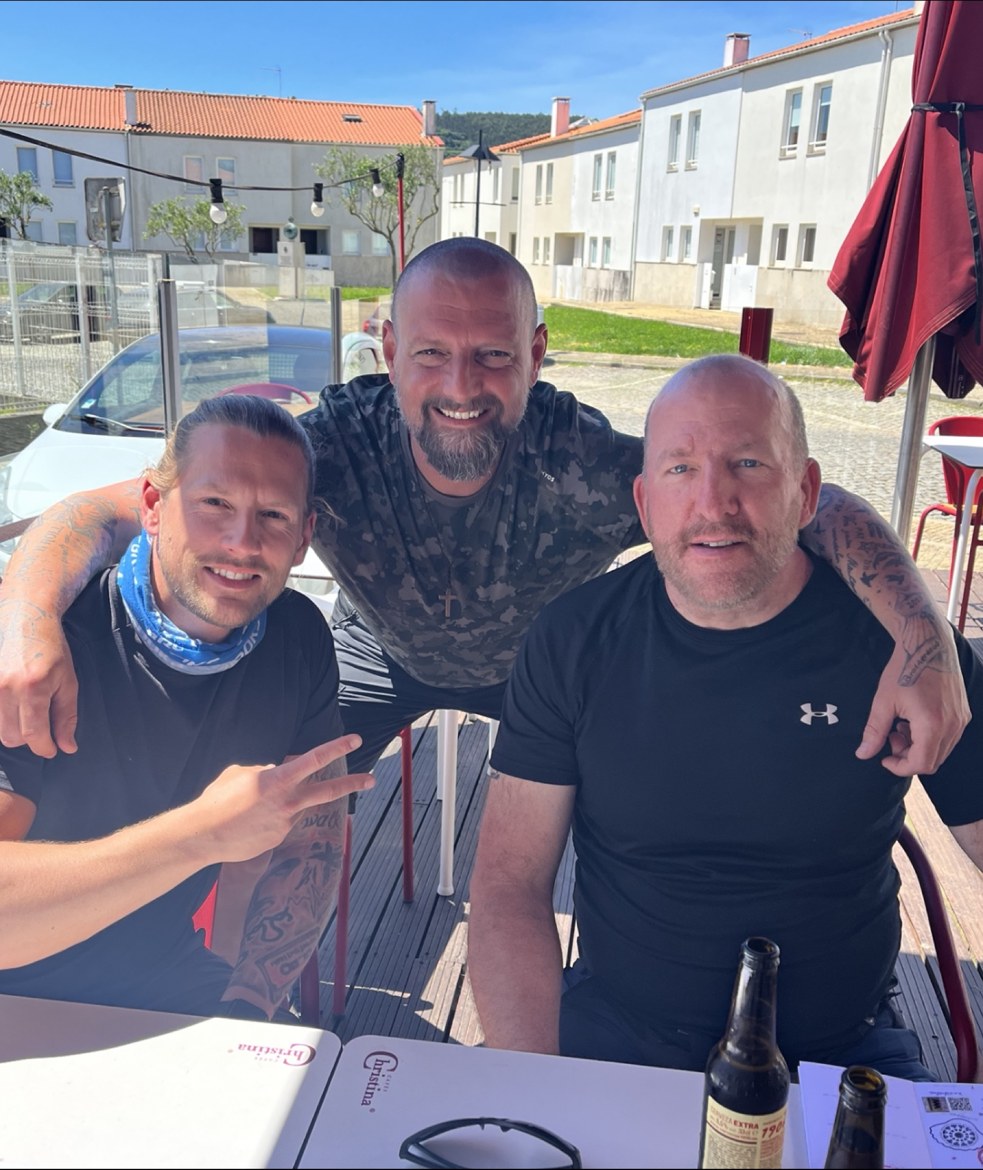 Nicki, Dennis and Mike around a sunny terrace table with beer bottles