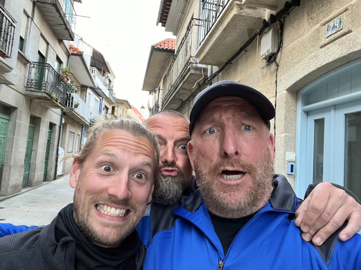 The three brothers pulling silly faces in a narrow Galician street