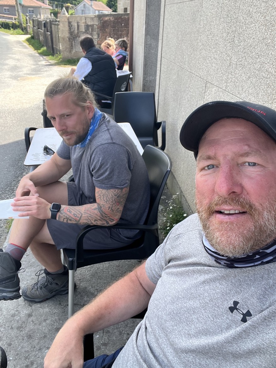 Dennis and Mike sitting at a roadside café table