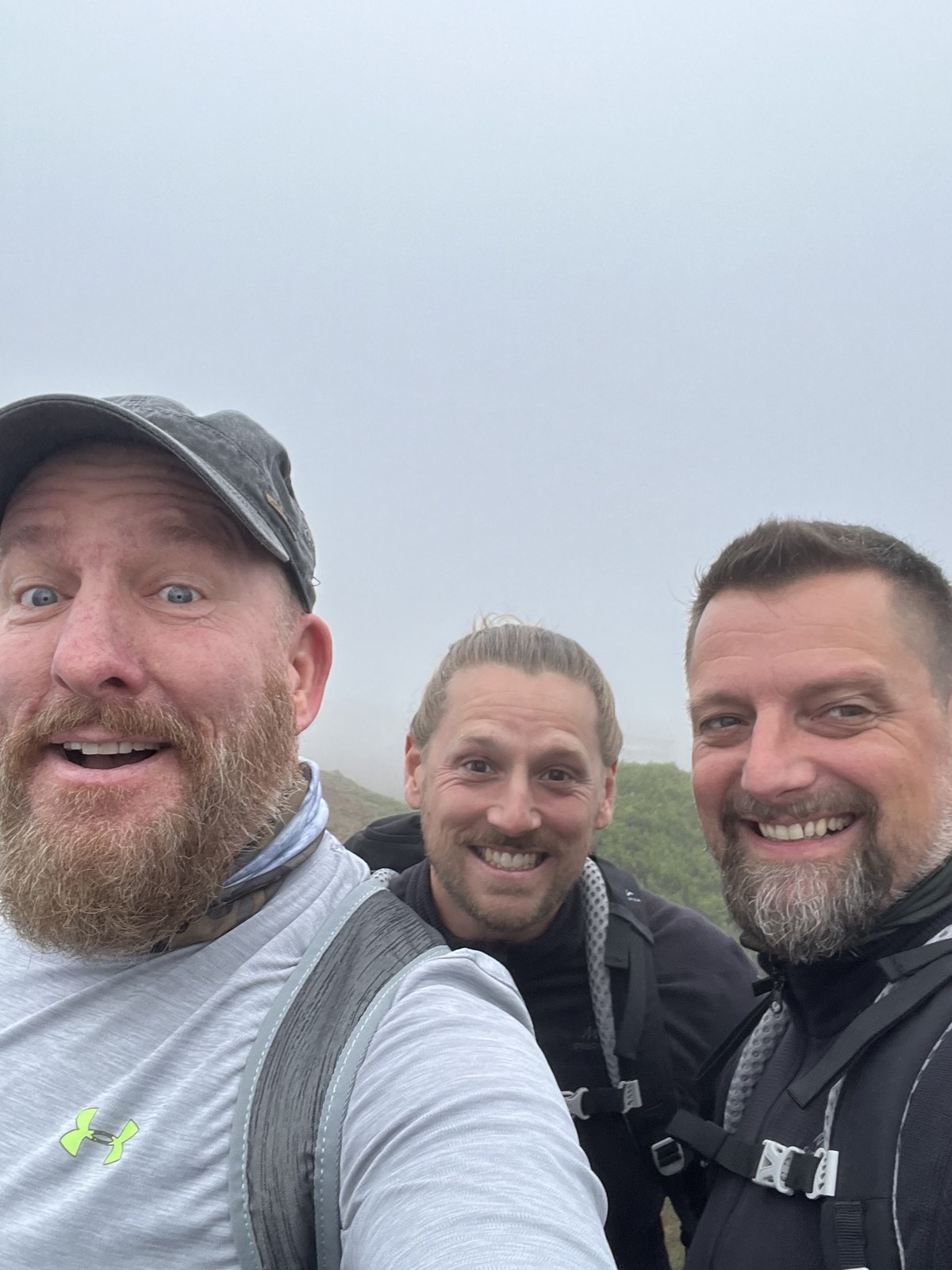 The three Camino Brothers taking a selfie in the mist, wearing backpacks