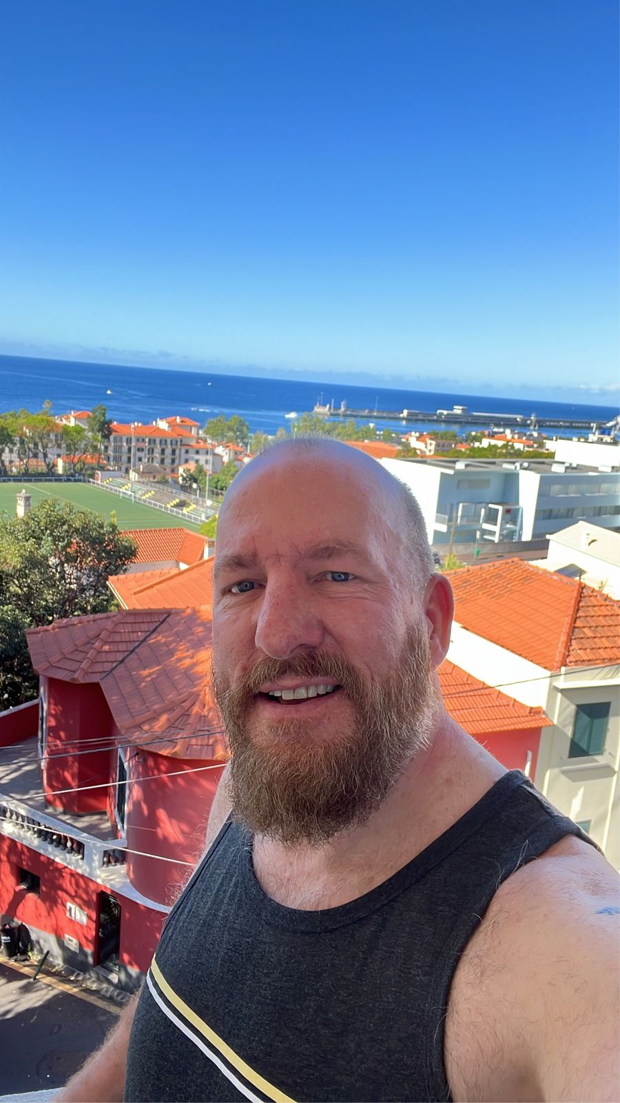 Mike taking a selfie above Funchal's red rooftops with the harbour behind him