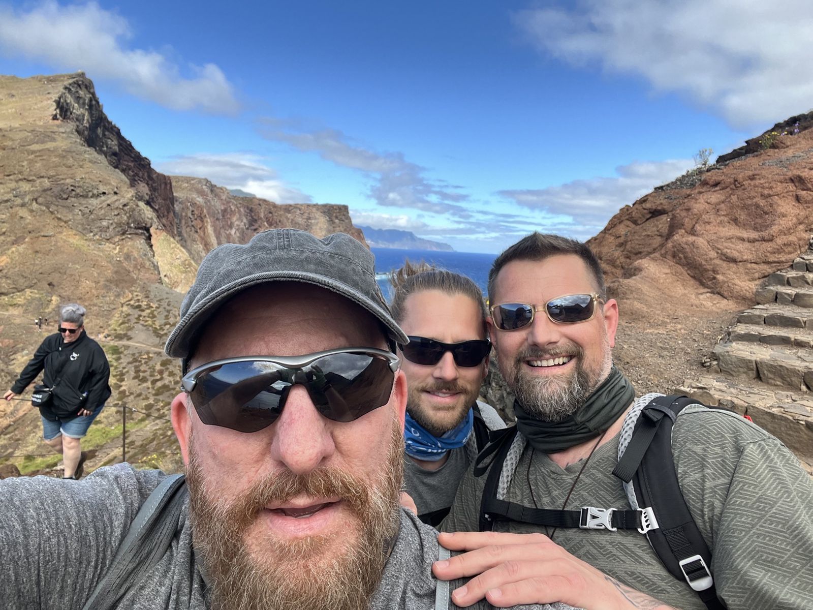 The three Camino Brothers taking a selfie on a red-rock coastal trail