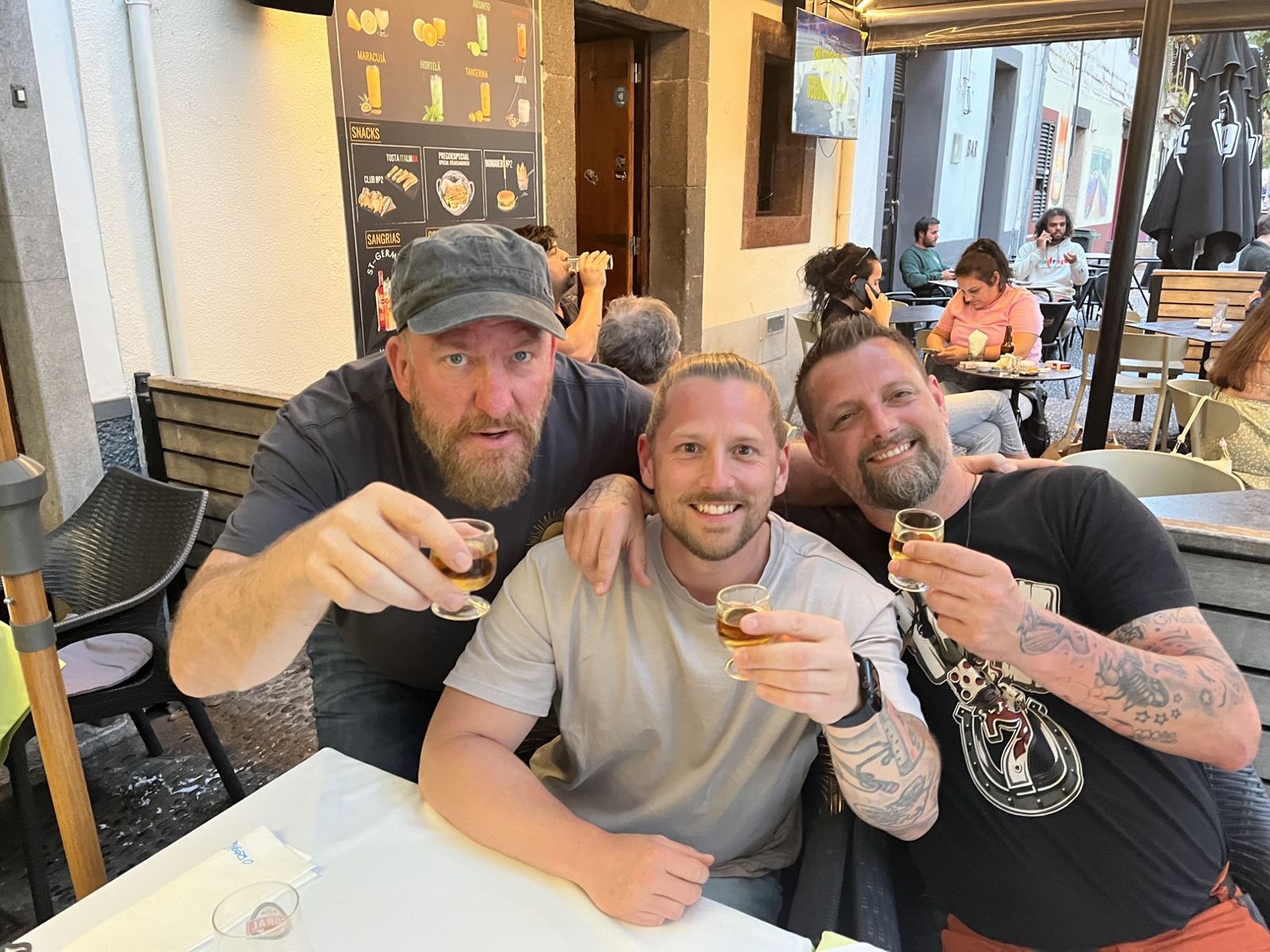 The three Camino Brothers raising small glasses at a Funchal bar