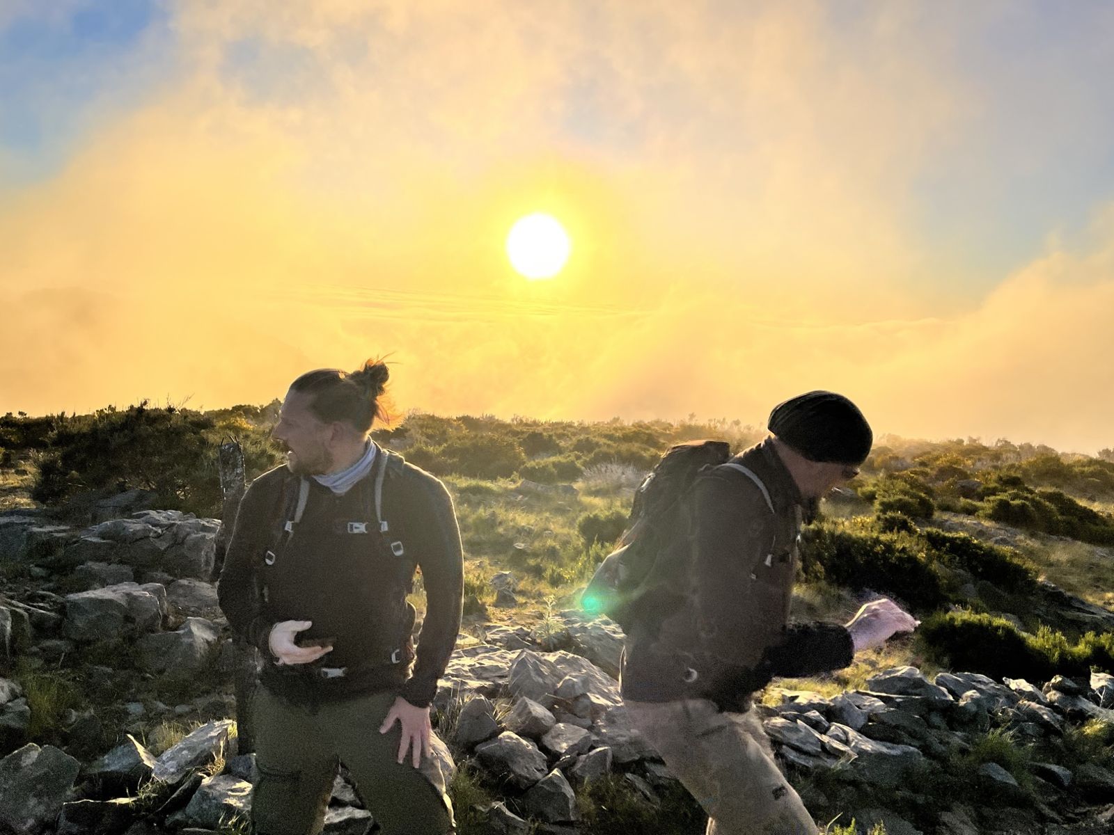 Two of the brothers walking in golden light above the clouds at sunrise