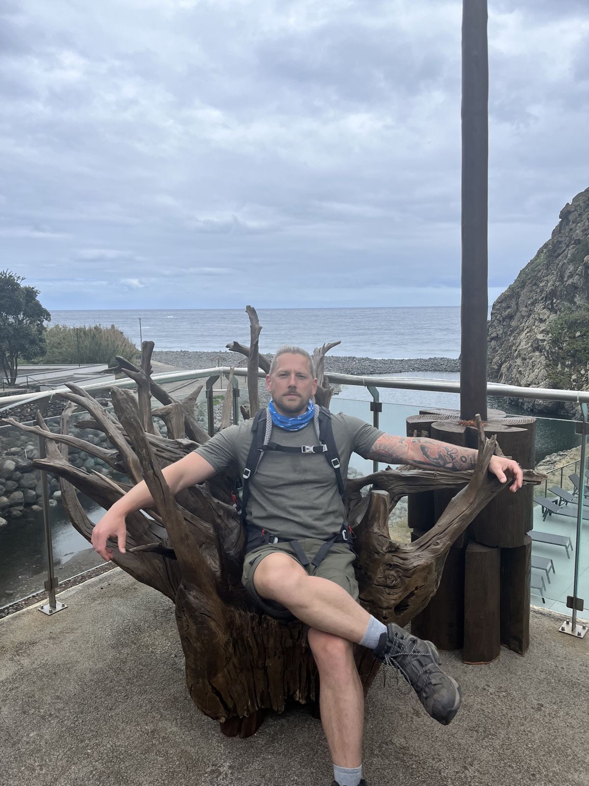 One of the brothers enthroned on a giant driftwood chair on a seaside terrace