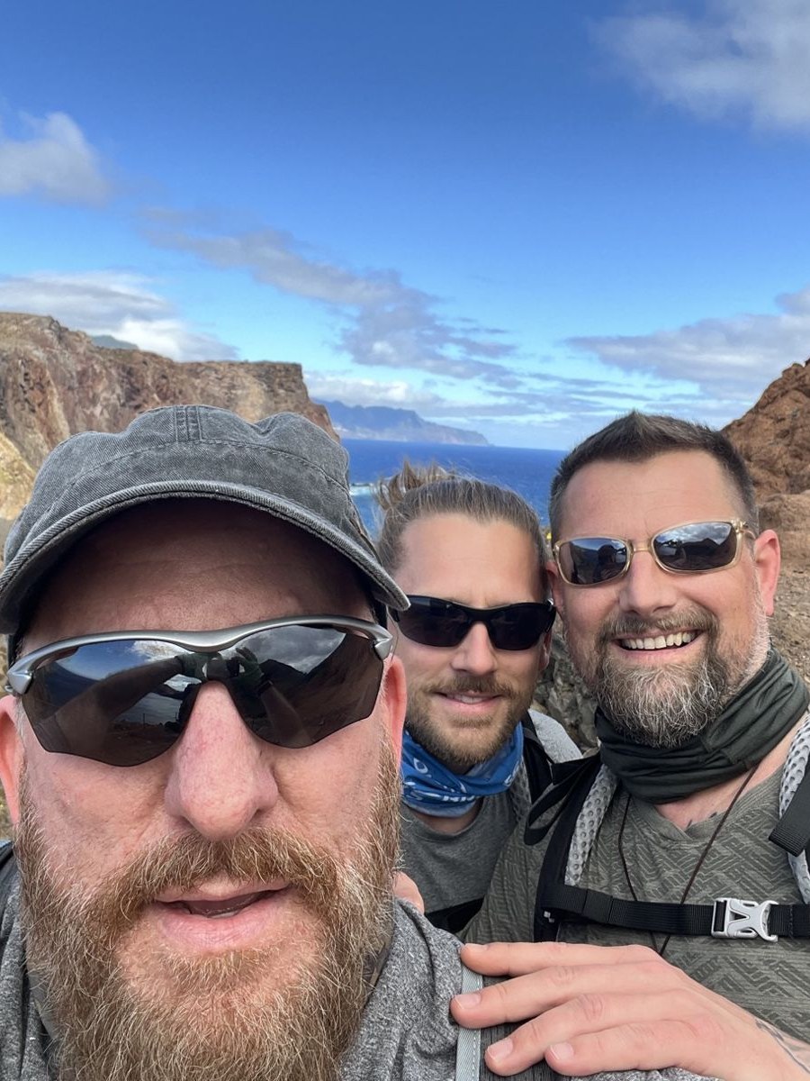 The three Camino Brothers taking a selfie on the São Lourenço peninsula, red cliffs and the Atlantic behind them