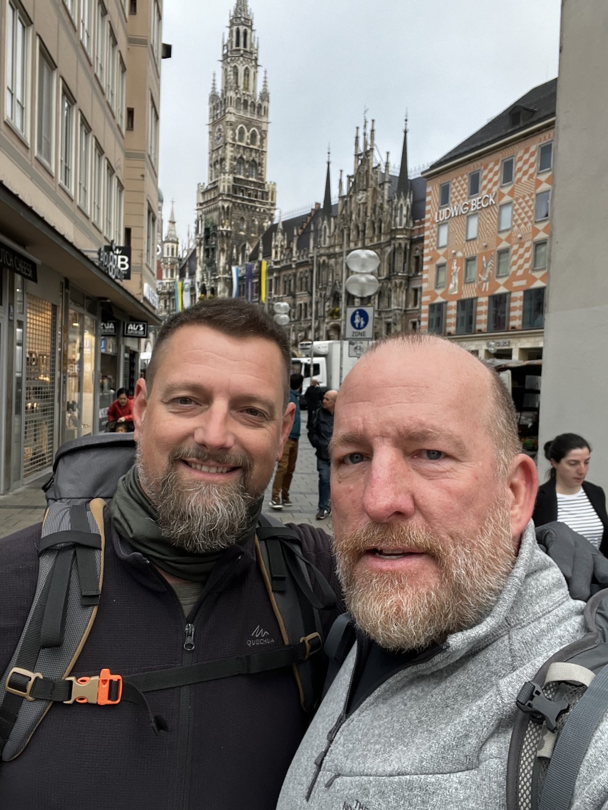 Nicki and Mike on Kaufingerstraße in Munich, the Rathaus tower behind, packs on