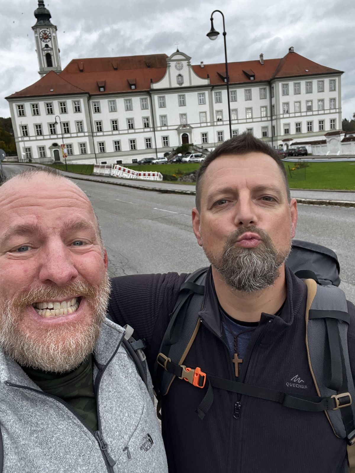 Mike and Nicki selfie in front of a large white abbey with a clock tower