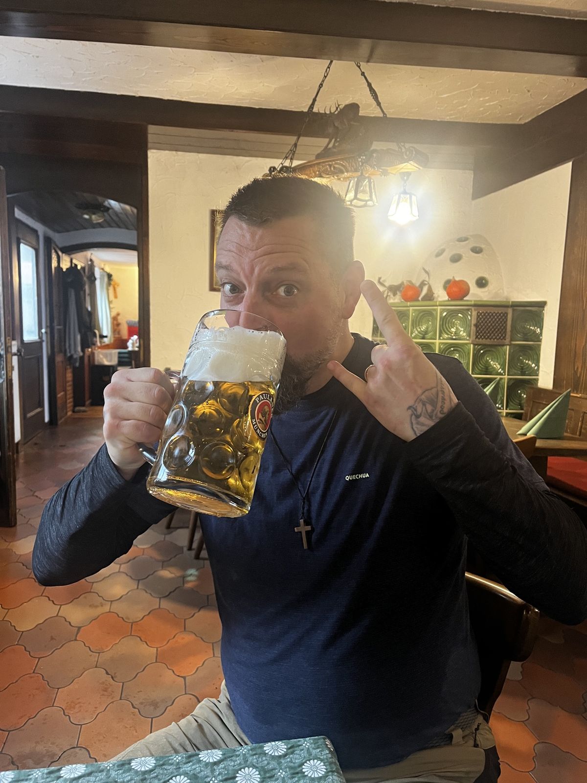 Nicki drinking from a Paulaner litre stein and making a rock-on gesture in a Gasthaus