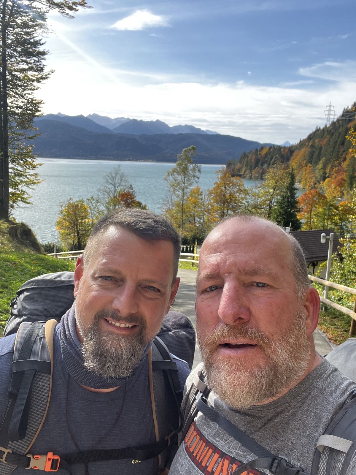 Mike and Nicki selfie above a blue lake with autumn trees and mountains