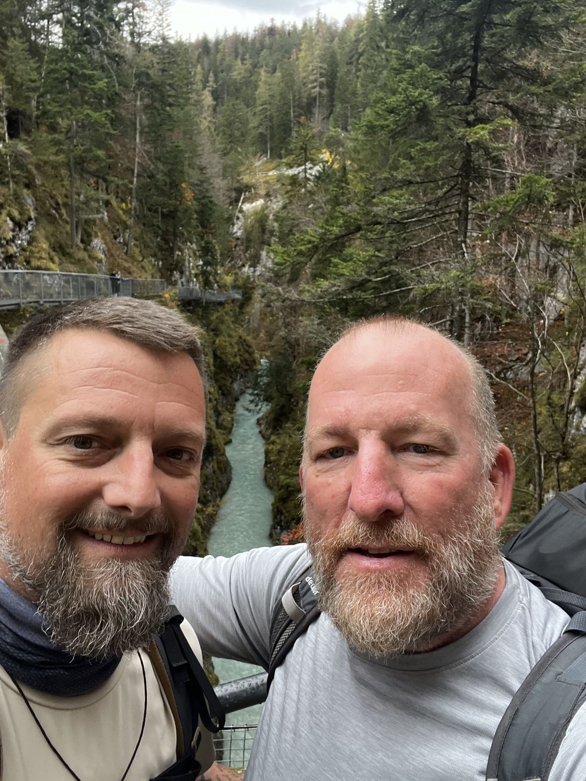Mike and Nicki selfie above a turquoise river running through a deep forest gorge