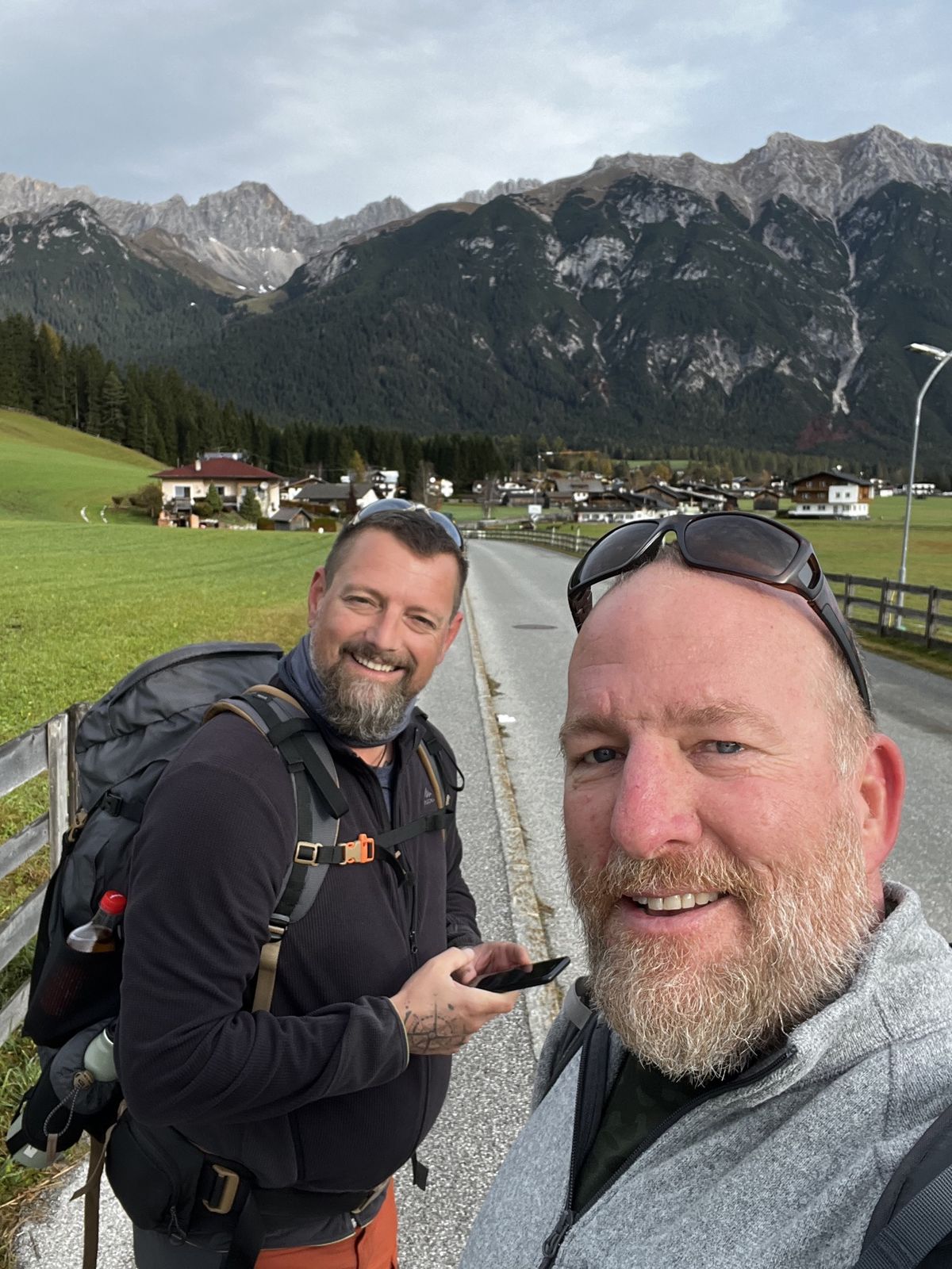 Mike and Nicki on a country road with green fields, a village and limestone peaks behind