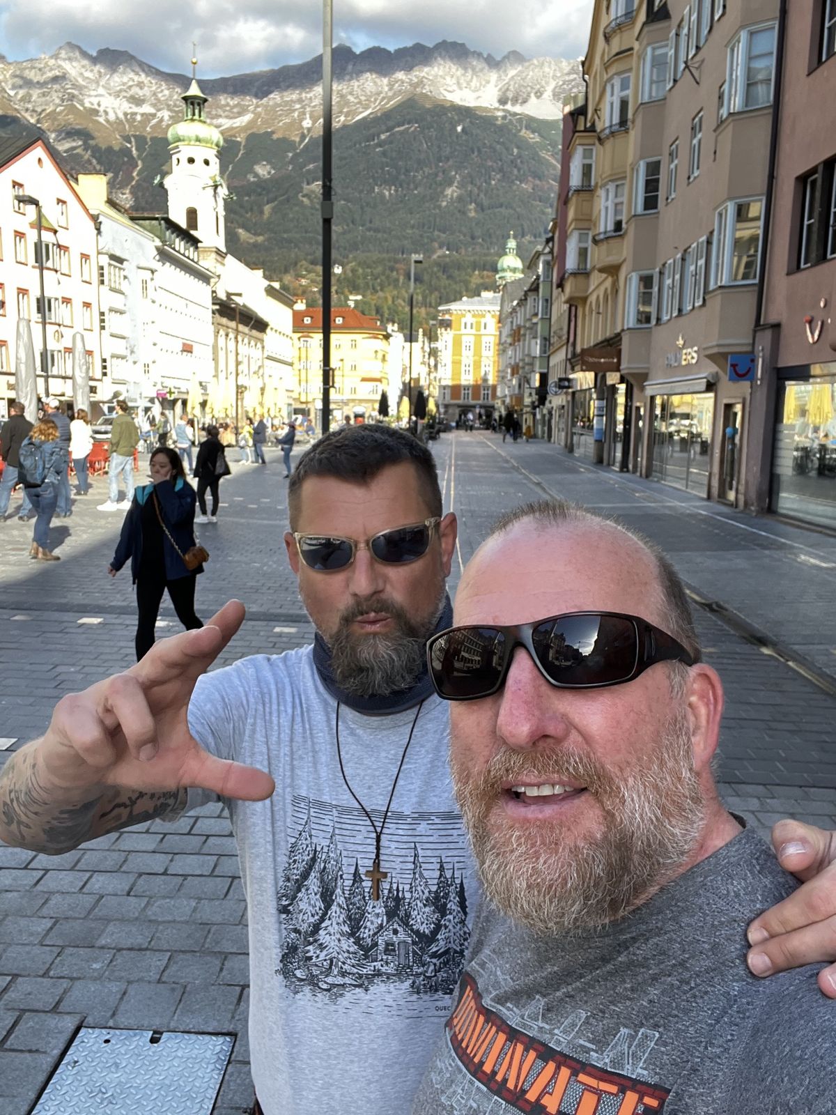 Mike and Nicki on Innsbruck's main street with snowy mountains behind the rooftops