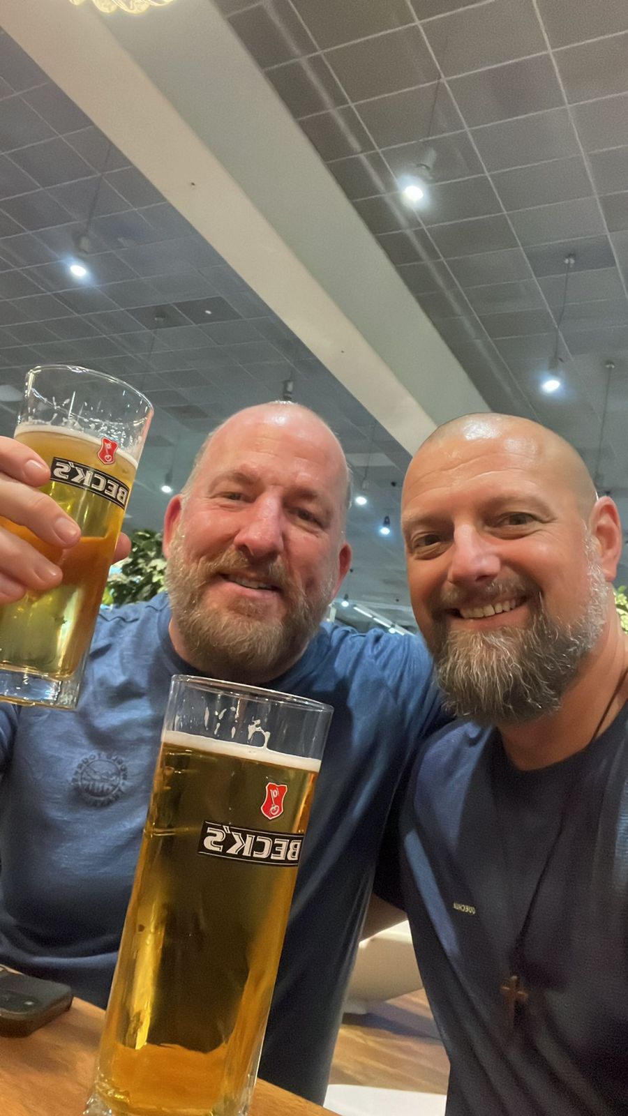 Mike and Nicki toasting with Beck's beers at an airport bar