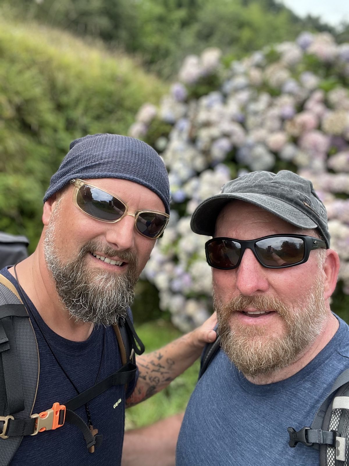 Nicki and Mike selfie in front of flowering hydrangea bushes