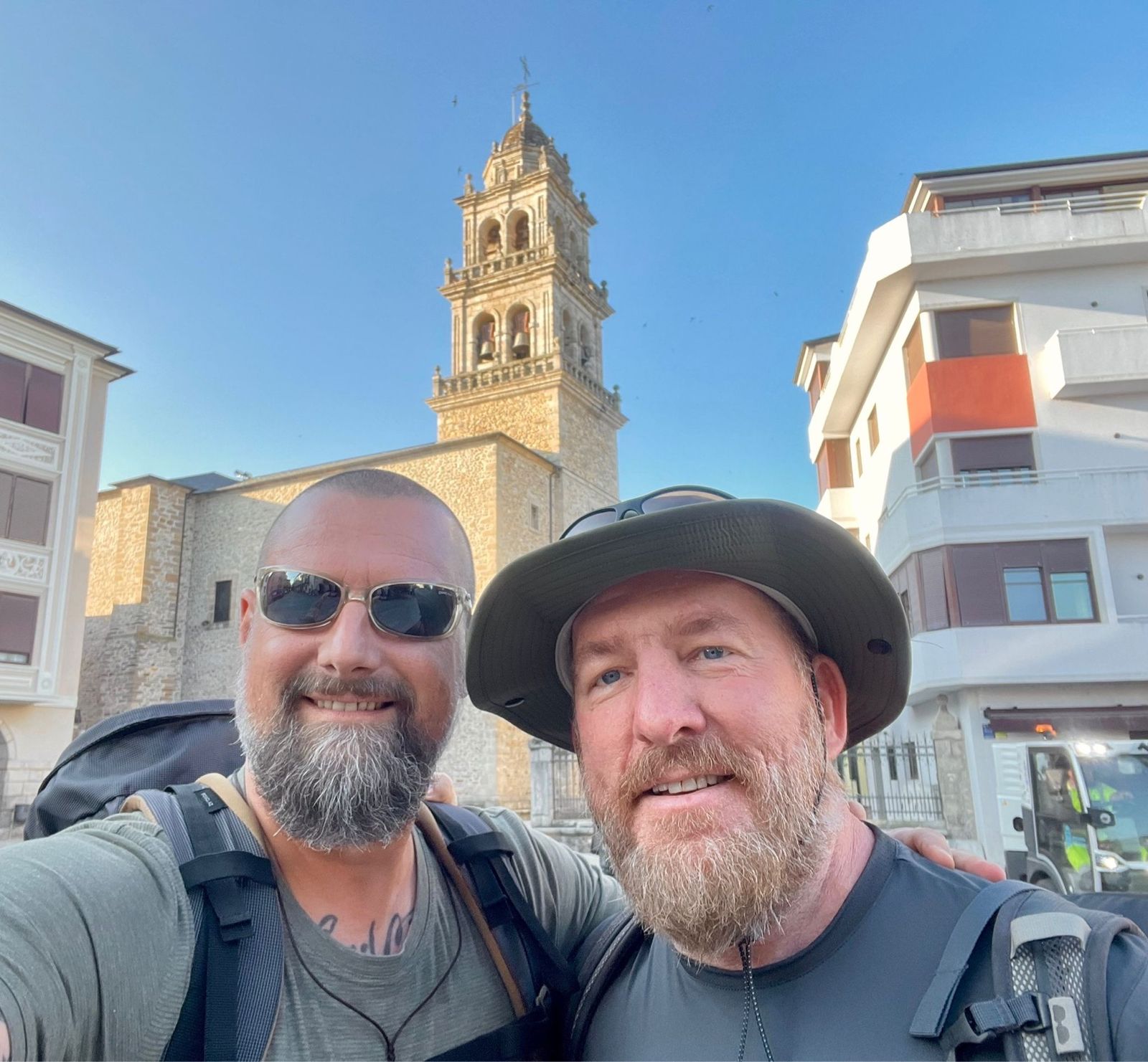 Nicki and Mike selfie in front of a stone church bell tower