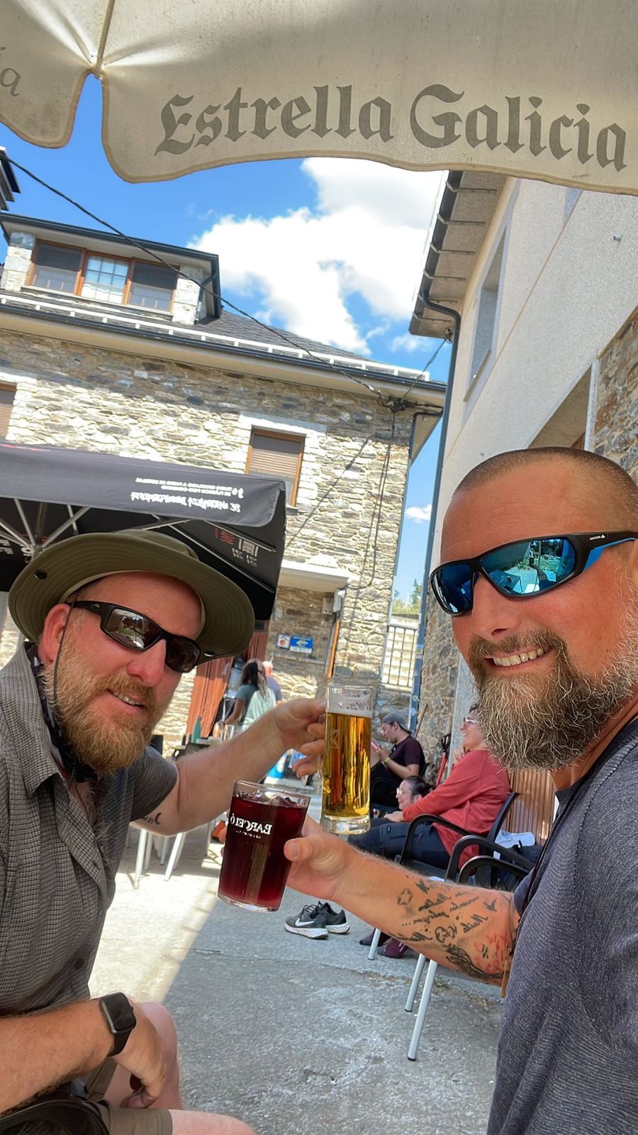 Mike and Nicki toasting with beer and tinto at an outdoor café