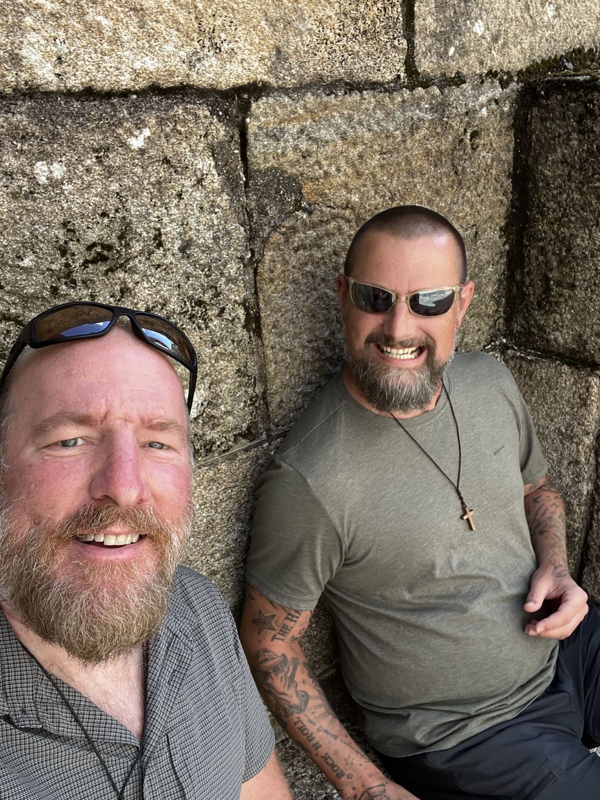 Mike and Nicki resting against the stone wall of Santiago cathedral