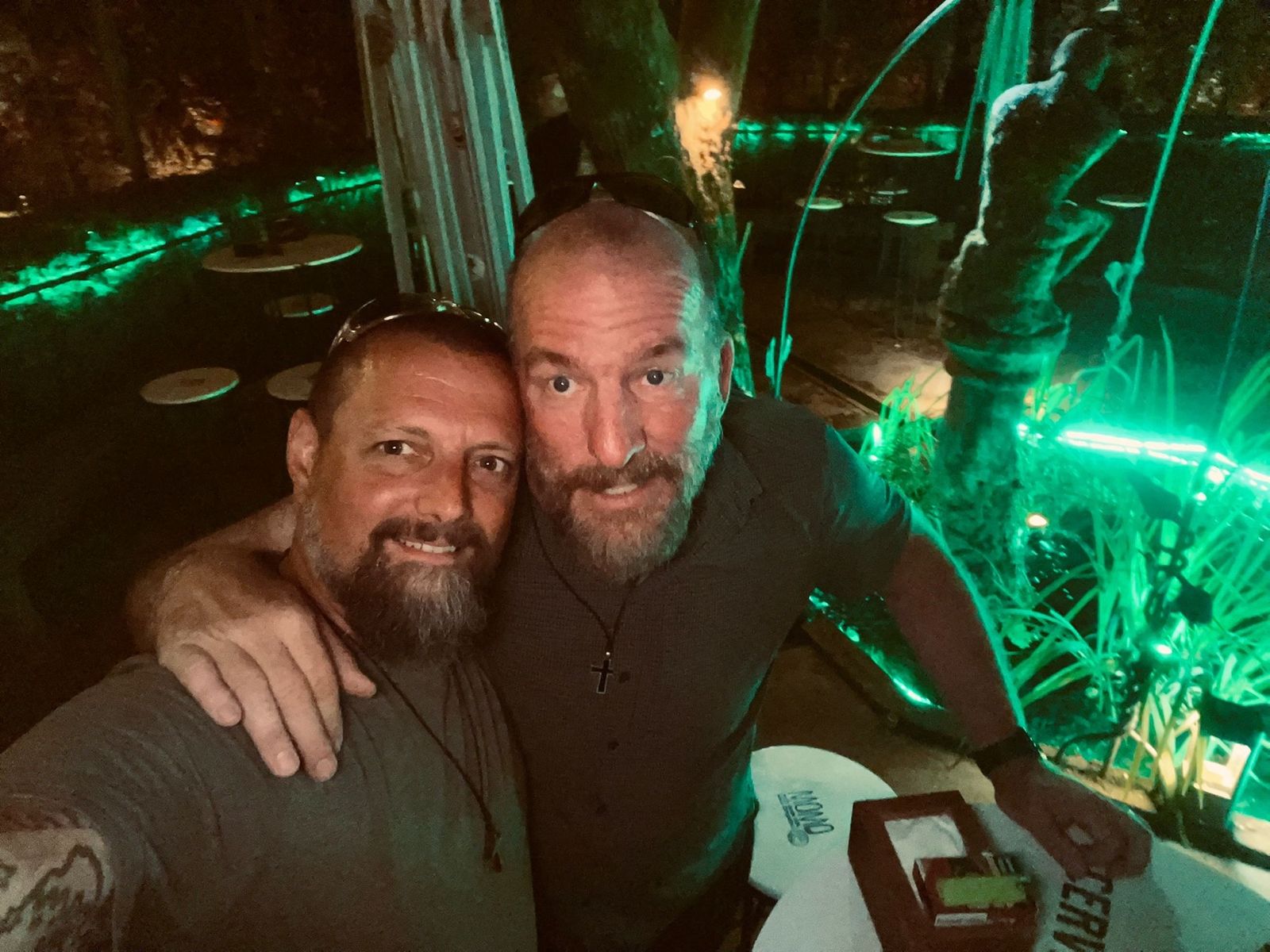 Nicki and Mike selfie at night beside a green-lit fountain