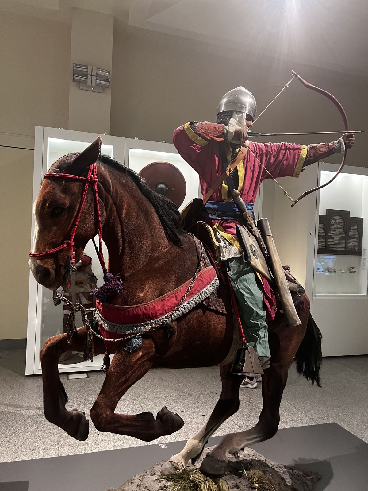 Museum display of a mounted medieval archer drawing his bow