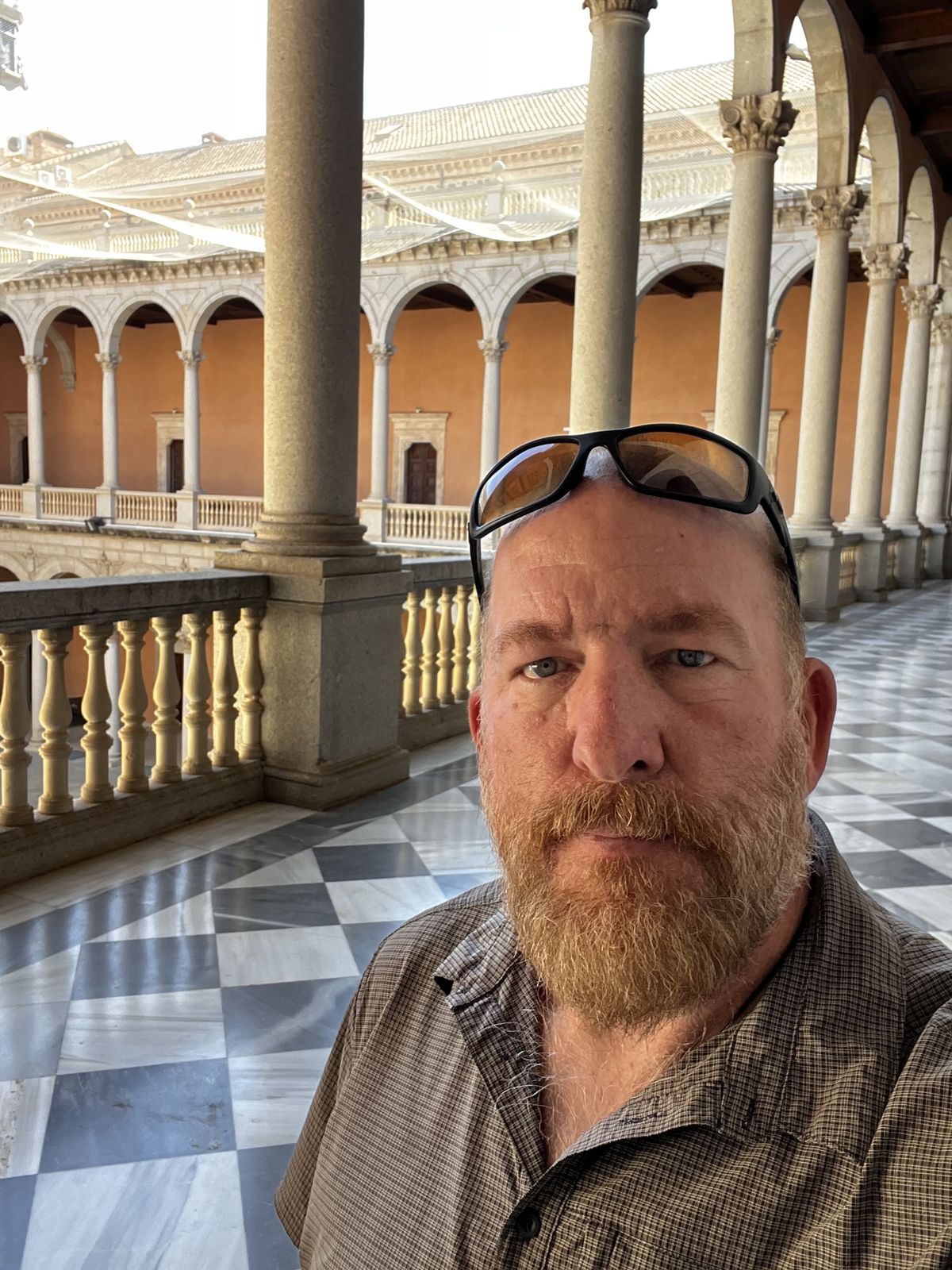 Mike selfie in a two-storey arched courtyard with a checkered marble floor