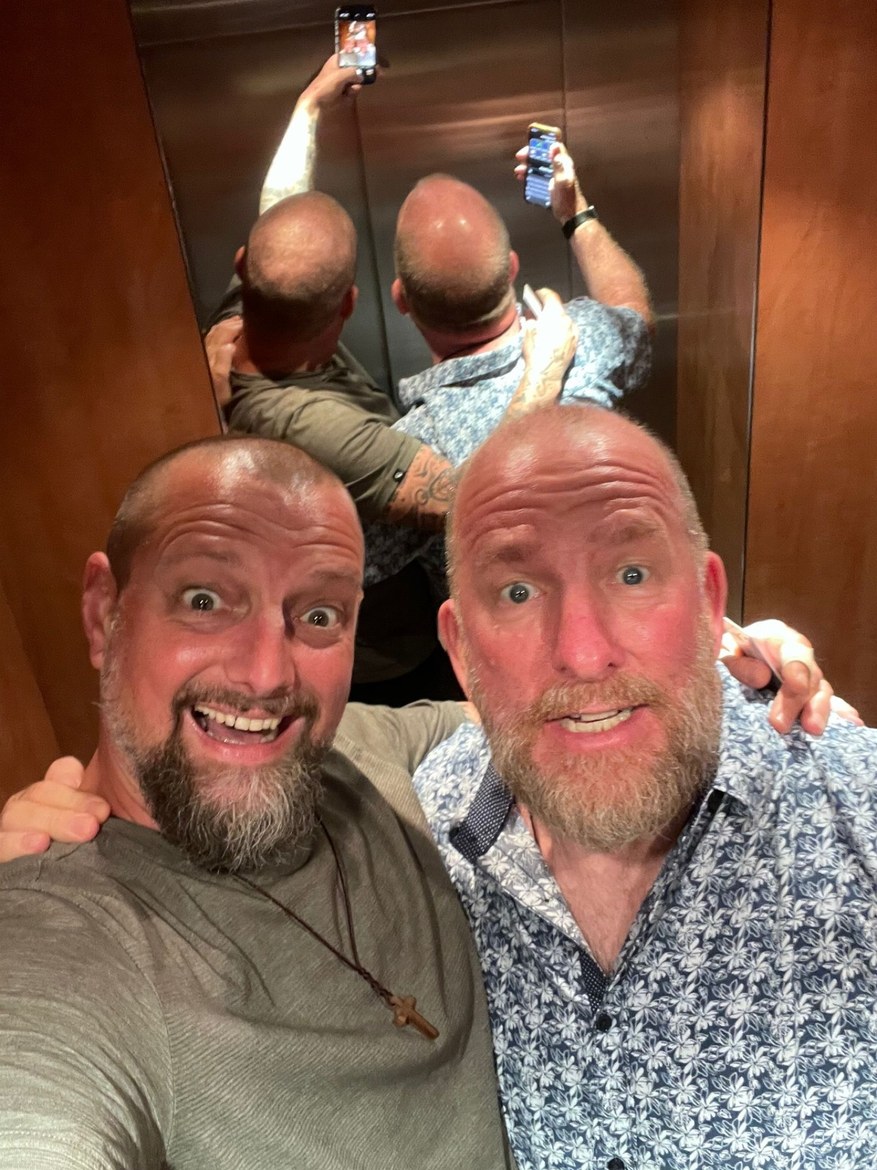 Nicki and Mike in an elevator mirror selfie, both holding their phones up