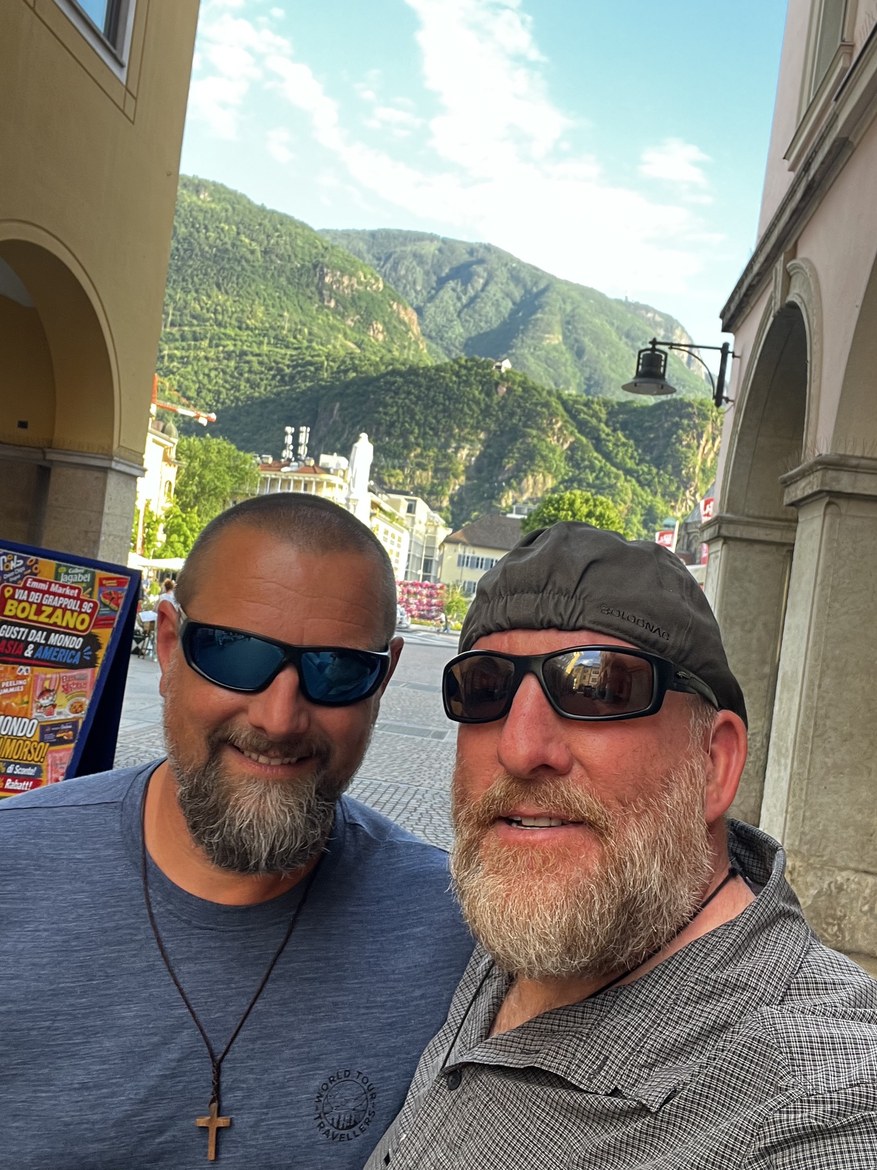 Nicki and Mike taking a selfie under the arcades in Bolzano, mountains behind the town